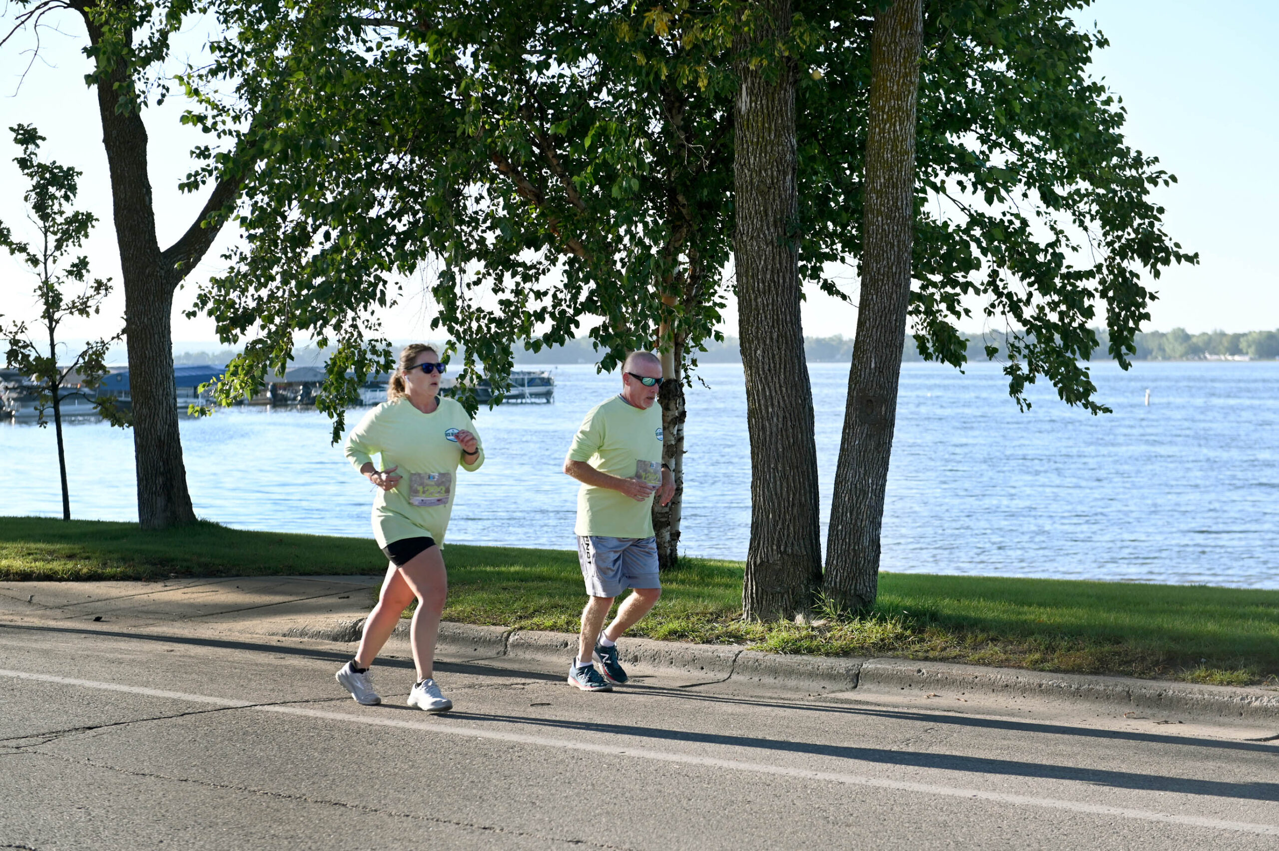 A female and male running with Detroit Lake in background.